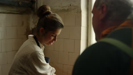 artista controlando el proceso de escultura en la cerámica. hombre enseñando a la chica en el estudio