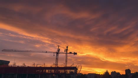 Espectacular-Y-Colorida-Puesta-De-Sol-Con-Nubes-En-Una-Ciudad-Con-Construcciones-Que-Funcionan-Como-Grúas-Y-Andamios-De-Primer-Orden