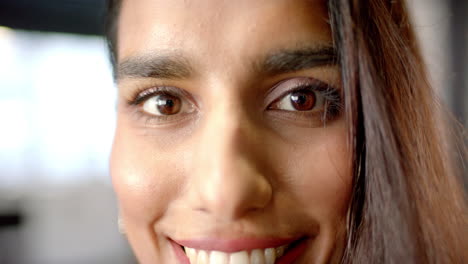 smiling woman with long hair looking directly at camera, close-up shot
