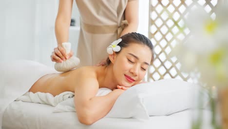 woman receiving thai herbal back massage