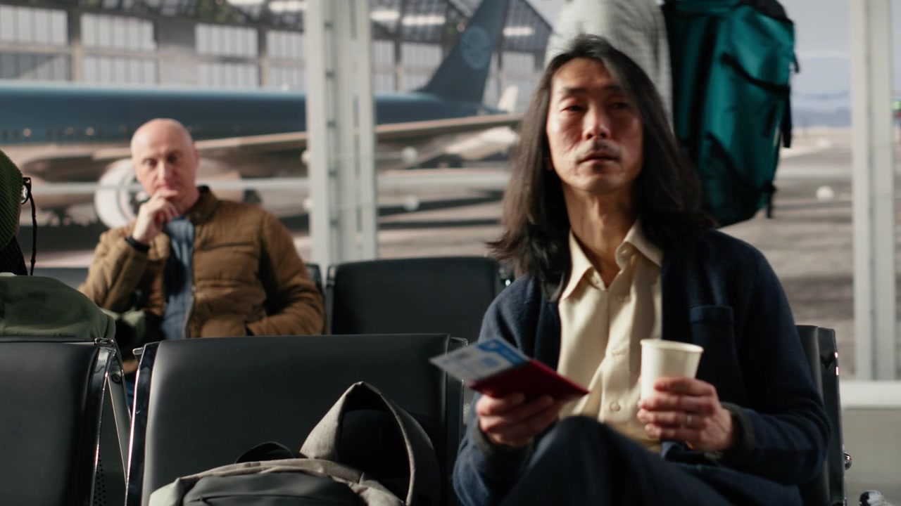 Primo piano di un uomo in aeroporto che tiene in mano documenti di viaggio durante un viaggio di lavoro