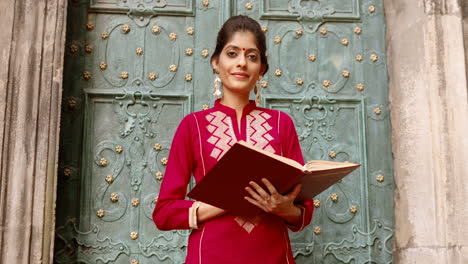 beautiful indian woman in red reading a book