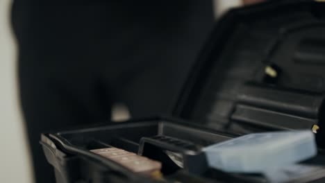 black man hands opening plastic tool box. closeup man hands taking screwdriver.