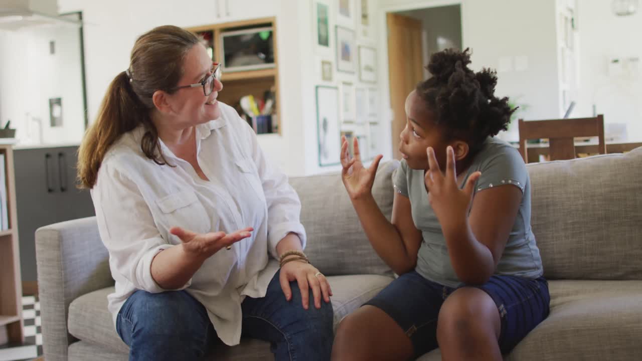 Caucasian woman arguing with her african american daughter in living room