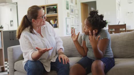 Caucasian-woman-arguing-with-her-african-american-daughter-in-living-room