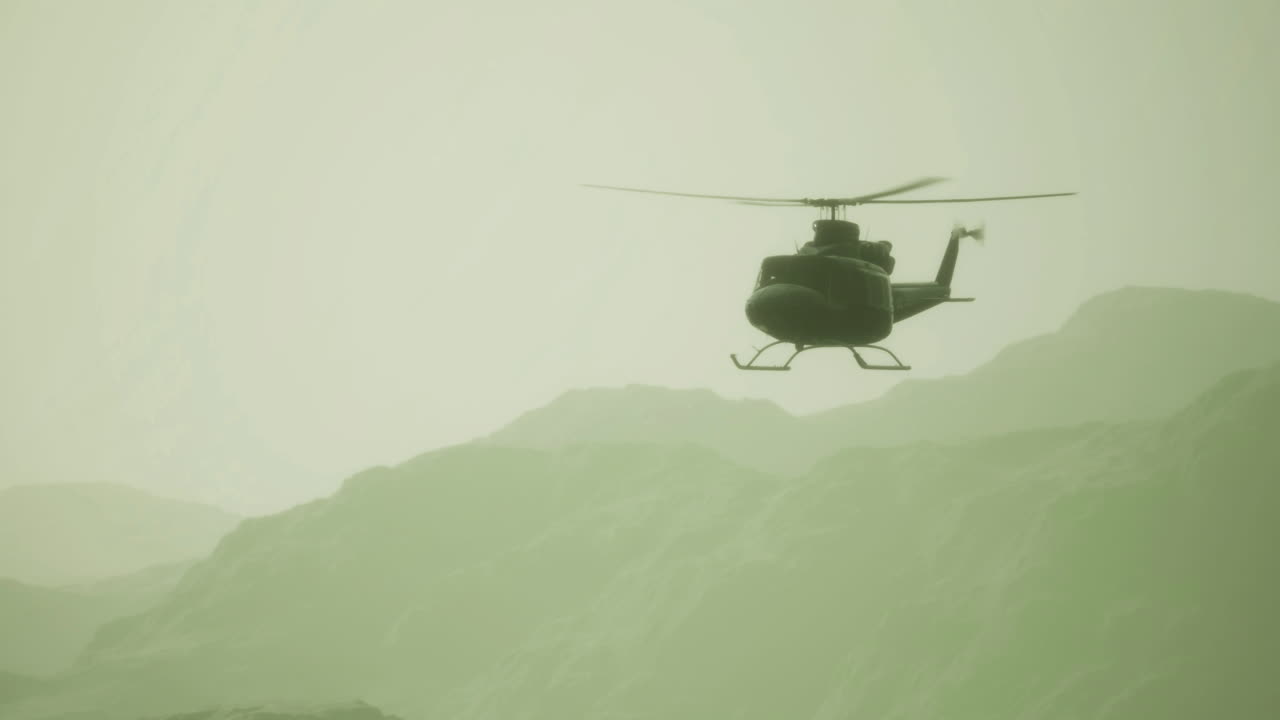 Helicopter gliding through misty mountains during dawn light