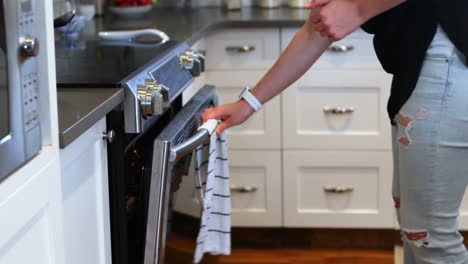 Woman-putting-cookie-tray-into-the-oven-4k