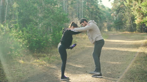 couple stretching in the forest
