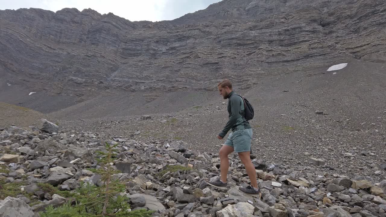 caminante caminando a través del anfiteatro de montaña seguido en un círculo rockies kananaskis alberta canada