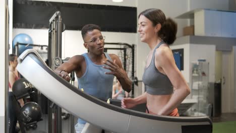 personal trainer guiding client on treadmill