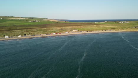 rural ireland from above, sandy beach garrylucas in county cork with mobile home parked and village houses