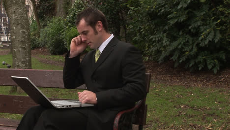 man working in park on laptop