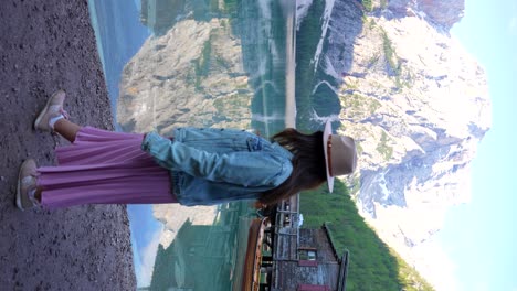 mujer paseando por el lago di braies con croda del becco en el fondo, italia
