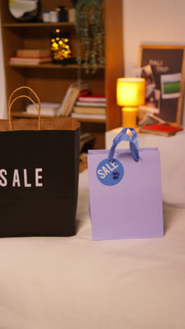 sale shopping bags on a bed