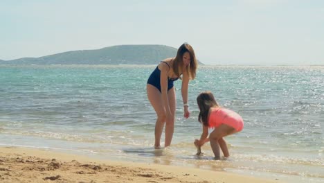 mother and daughter having fun at the beach 4k