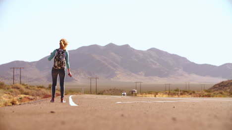 woman hitchhiking along road using mobile phone shot on r3d