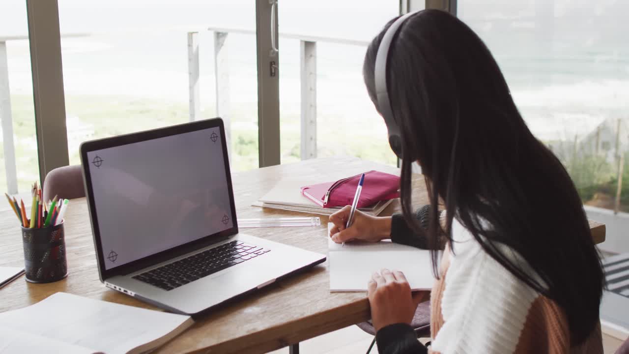 카피 공간이 있는 노트북으로 학습하는 헤드폰을 착용한 행복한 두 인종 여성의 비디오