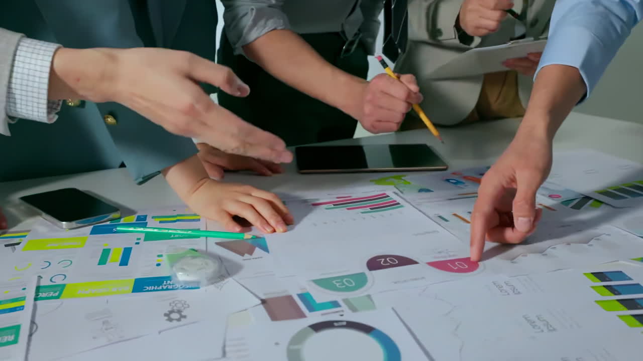 Team of business people working together in the meeting room office analysts strategizing on charts and data. Financial analysts discuss bars and graphs, using calculator to analyze data