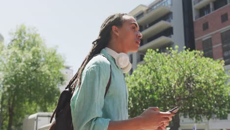 Mixed-race-man-using-his-phone-outside