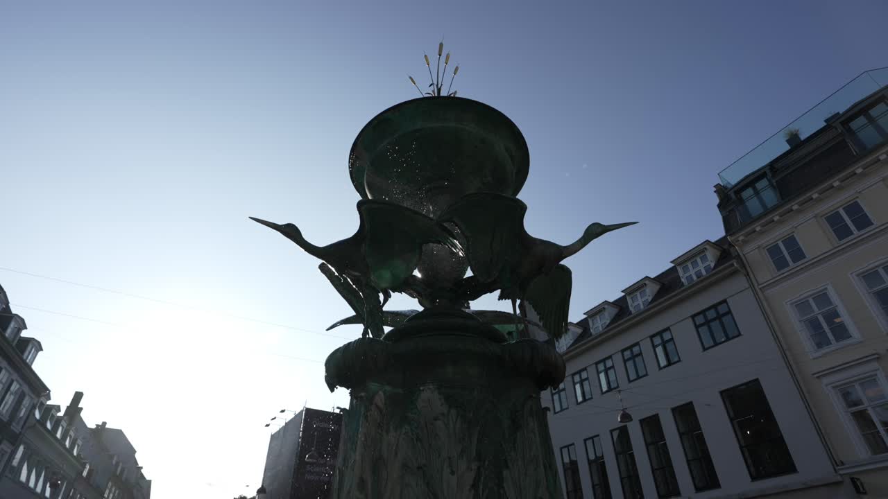 Slow motion of water droplets flowing down from a fountain top, Copenhagen, Denmark, at dusk