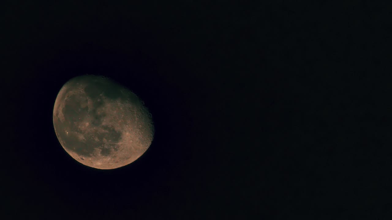 Uma imagem detalhada em close-up da lua contra um céu noturno escuro, exibindo suas crateras e textura da superfície