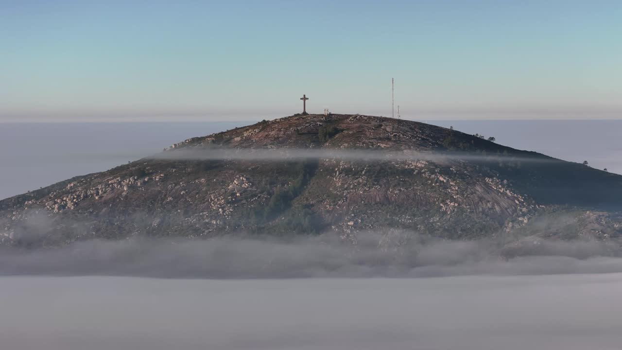 Close-up timelapse of Pan de Azúcar summit in Maldonado, Uruguay, rising above low clouds with rotating view, dramatic sky, and warm golden hour light