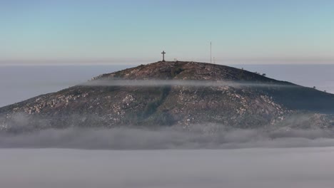 close-up timelapse of pan de azúcar summit in maldonado, uruguay, rising above low clouds with rotating view, dramatic sky, and warm golden hour light