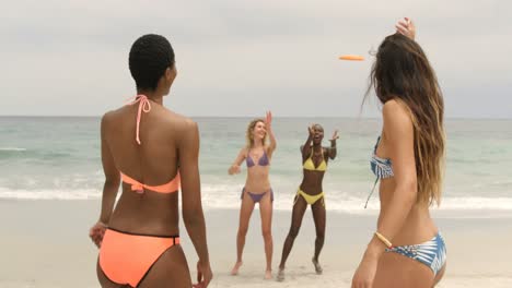 group of mixed-race female friends playing flying disc on the beach 4k