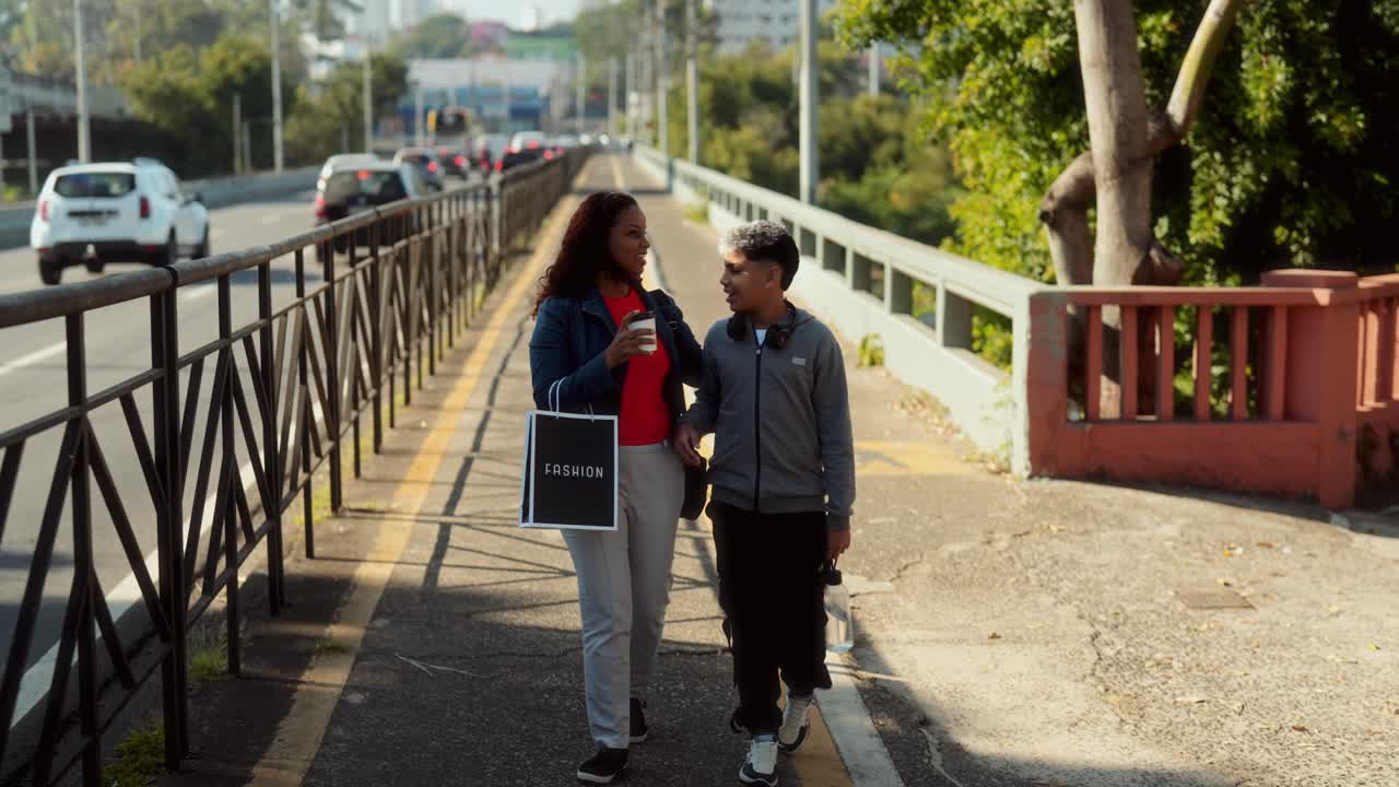 Mother and Son Walk Hand in Hand with a Shopping Bag in the City