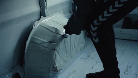 young man cleaning rust from van interior, close up view