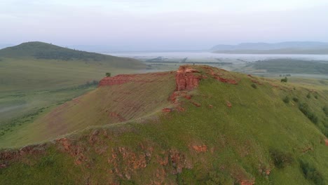 aerial view of a mountain cliff with a person standing on top