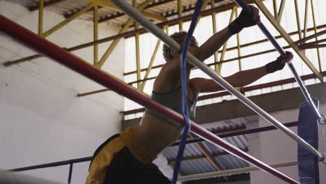 mixed race woman stretching in boxing ring