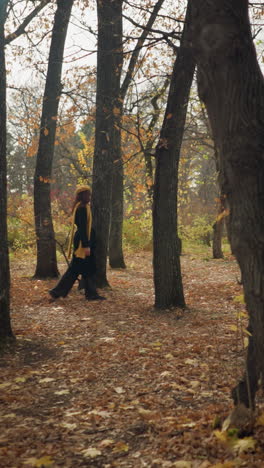 turista caminando por un pacífico bosque de otoño, rodeado de árboles altos y hojas doradas, disfrutando del aire fresco y la tranquilidad de la naturaleza, vestido con un elegante abrigo negro y bufanda amarilla