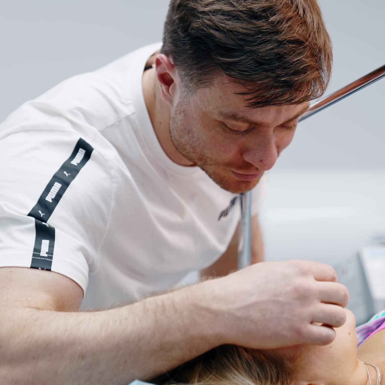Loving man soothes his wife lying on the operational table. Husband strokes head of woman before C-section surgery