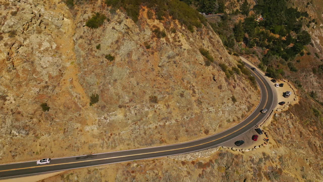 Wavy road through the mountains. Highway with place for stop to watch the nature and sightseeing. Sunny day background.