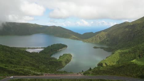 Serene-view-of-Lagoa-do-Fogo-lake-surrounded-by-lush-green-mountains-under-a-cloudy-sky