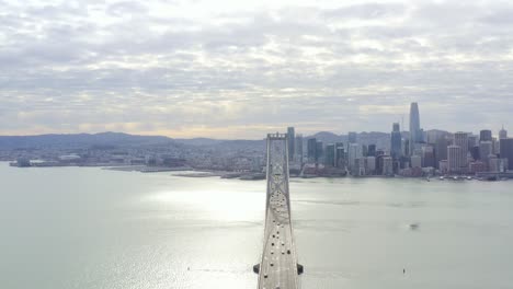 aerial: people driving over the bridge towards the city