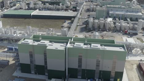 aerial view of two large, modern industrial buildings within a sprawling factory complex with tanks and piping, castets, france