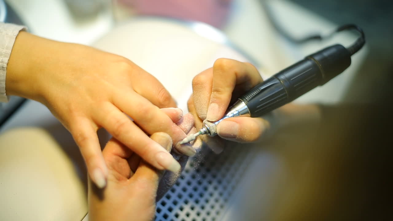 Woman paint nails with lacquer in the beauty salon
