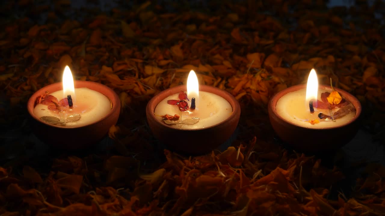 Human hands take away a diya and then replaces it. Diyas or lamps lit up for Diwali 'Festival of light', the most important ancient Hindu festival celebrated signifying victory of light over darkness