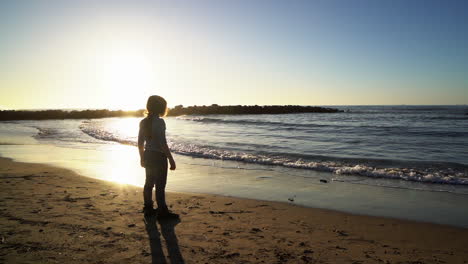 Red-haired-little-girl-on-beach-look-at-ocean