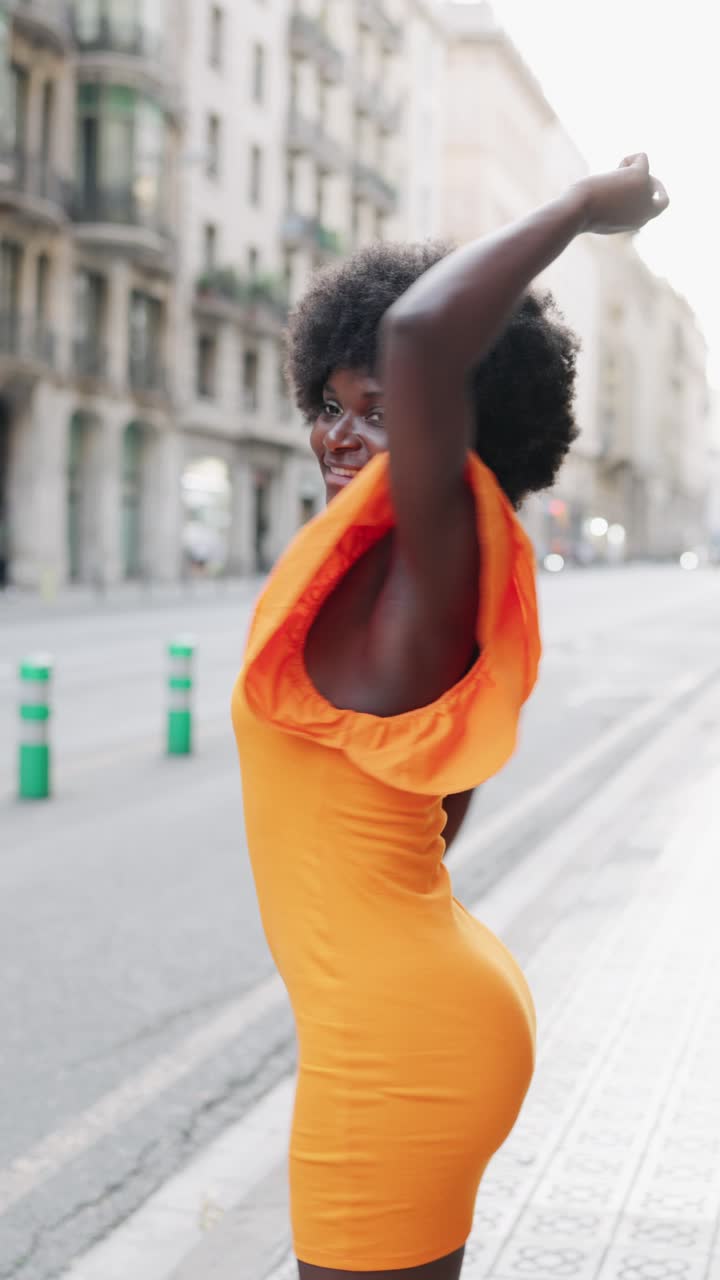 Woman in Orange Dress on City Street
