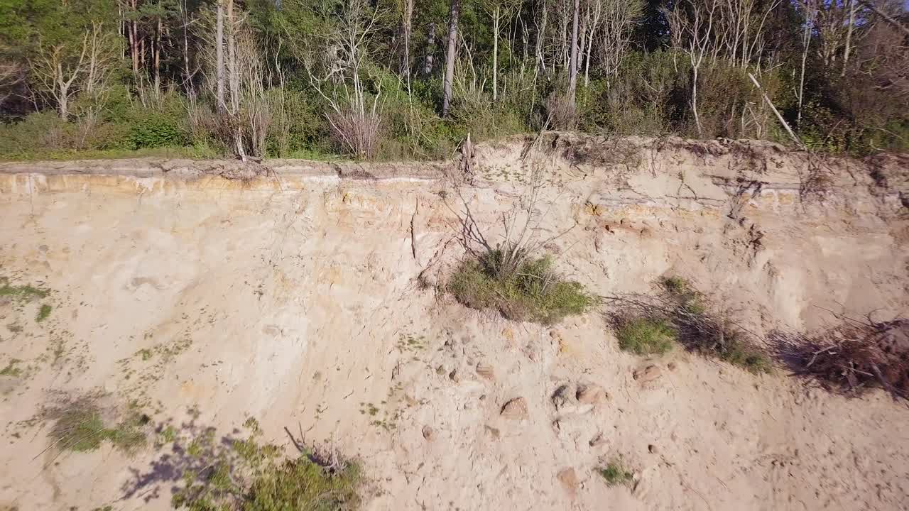 vista aérea de la playa del mar báltico en jurkalne en un día soleado, acantilado de arena blanca dañado por las olas, erosión costera, cambios climáticos, gran angular que revela disparos de drones moviéndose hacia atrás-1
