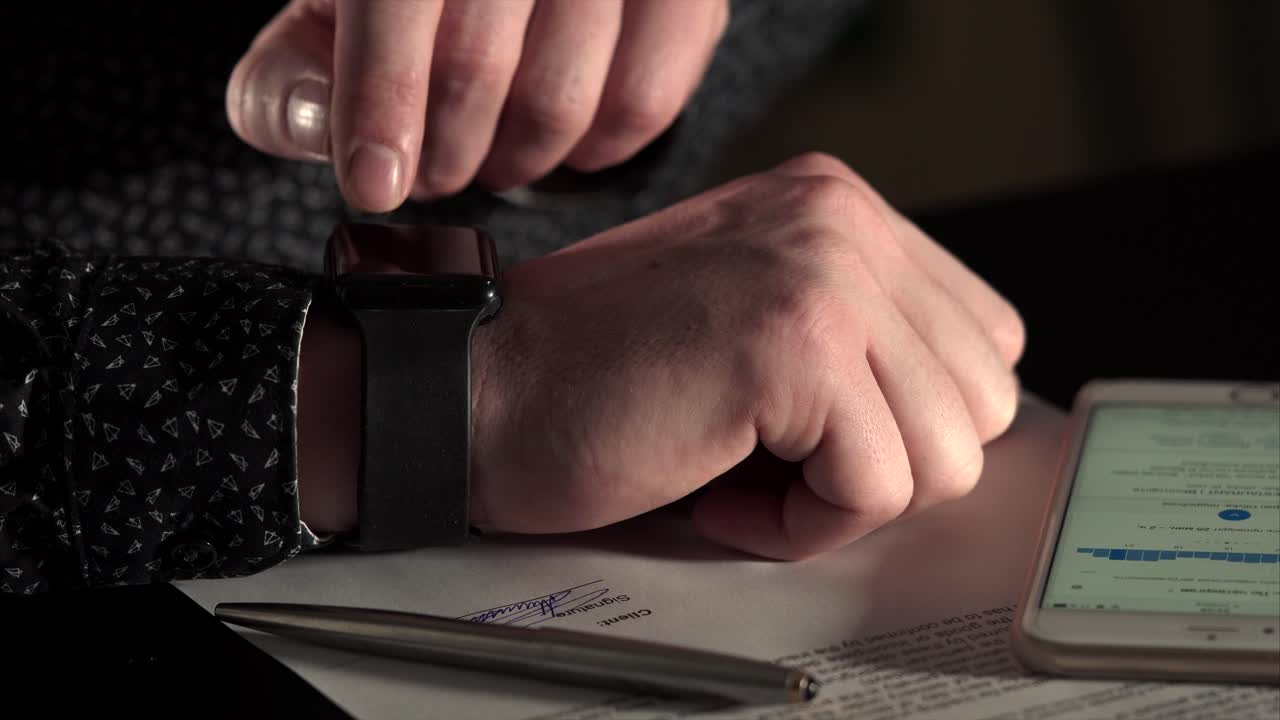Man signing a document with a smart watch
