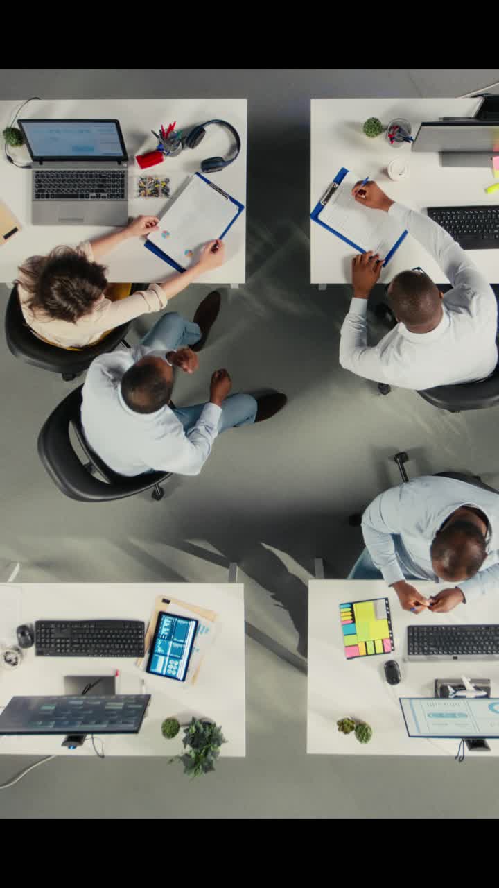 Vertical Video Top down view of business colleagues using computers to analyze insights