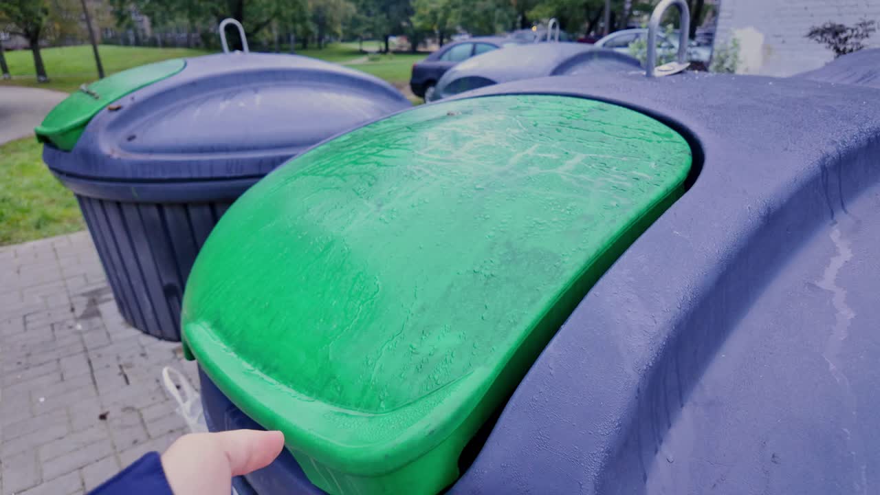 Man opening garbage container showing urban waste management awareness