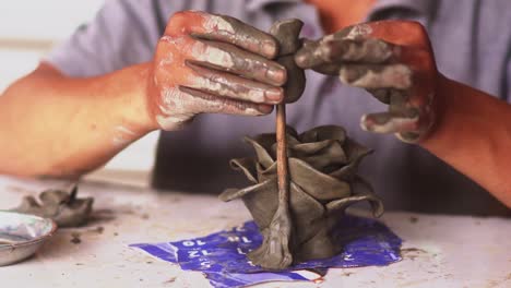 sculptor man creating sculpture from clay in workshop