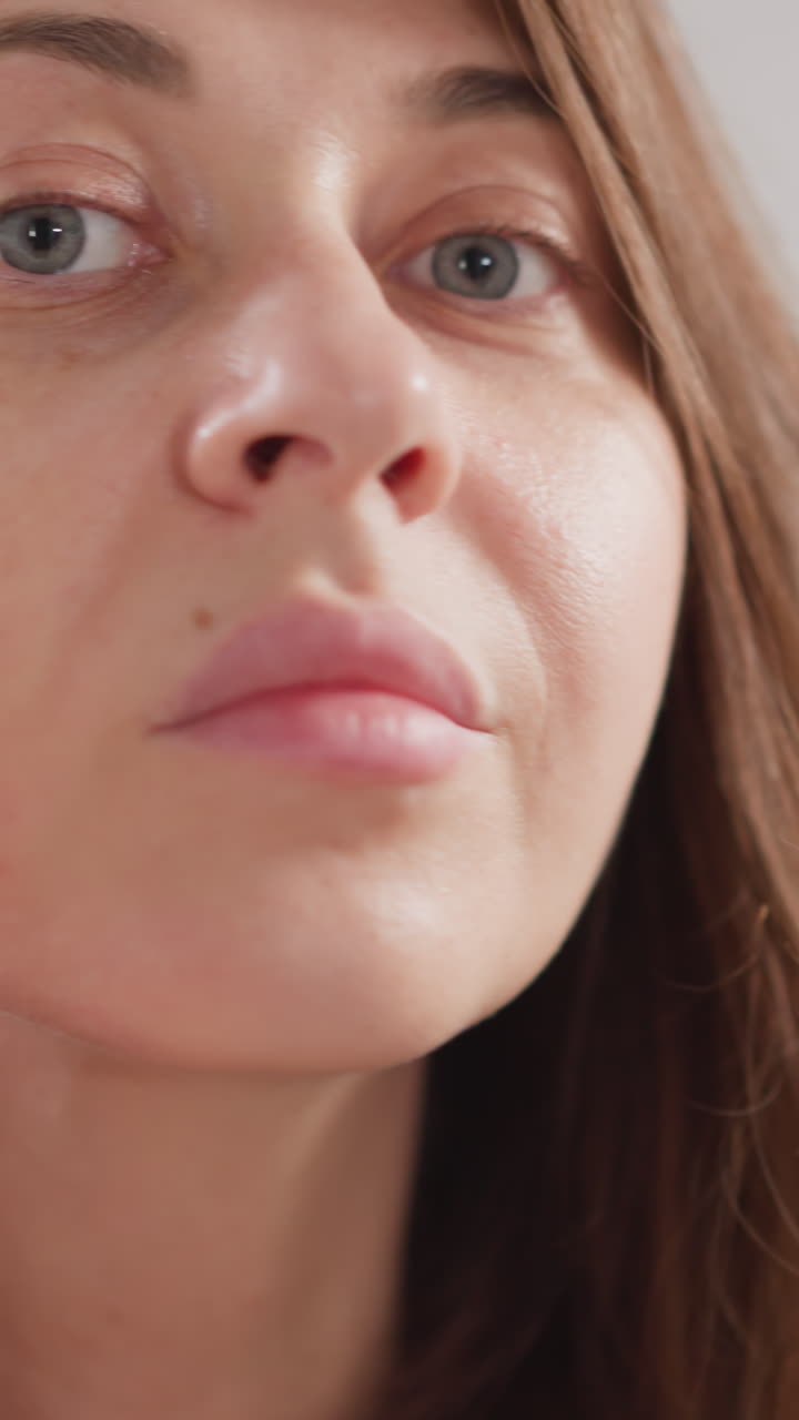 una mujer examina la piel facial con los dedos en la ducha. una mujer bonita con emociones positivas siente felicidad después de tratamientos de belleza en un moderno salón de spa