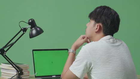 녹색 화면으로 노트북을 사용하는 사람