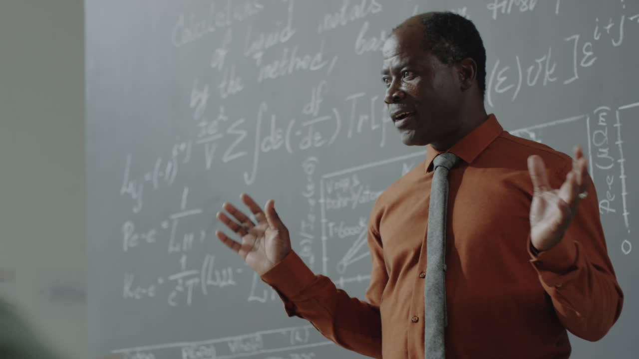 African American Professor Lecturing in Front of a Chalkboard Filled with Equations